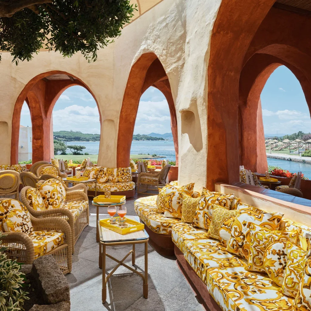 Terasa hotela Cala di Volpe na Sardínii so žltými pohovkami so stredomorským majolikovaným vzorom Maiolica Gialla od Dolce & Gabbana.