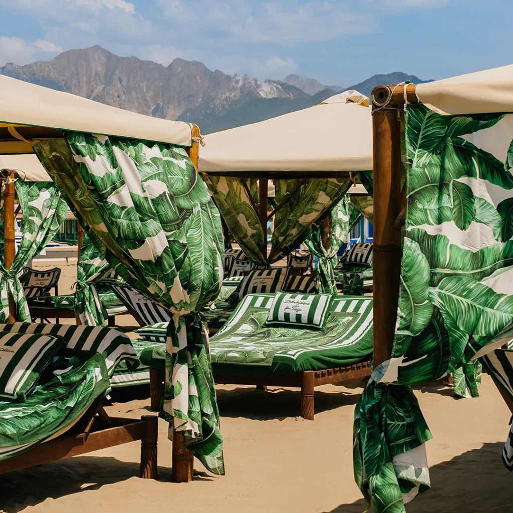 Luxusné plážové postele s baldachýnmi potiahnutými zeleným banánovým vzorom od Dolce & Gabbana v klube Twiga vo Forte dei Marmi.