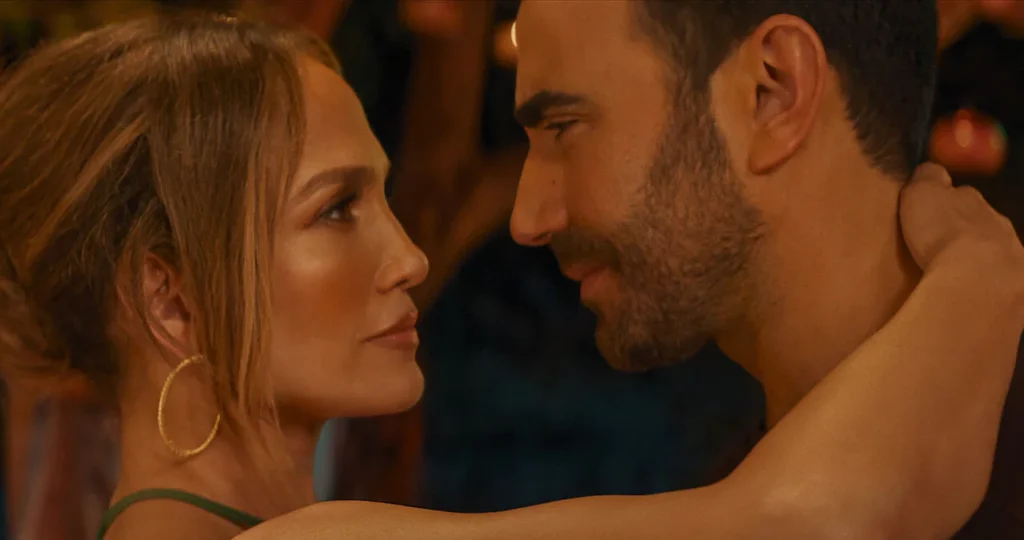 Detailný záber na Jennifer Lopez a Bretta Goldsteina, ktorí si pozerajú hlboko do očí v romantickej scéne z filmu Office Romance (Pracovní romance).