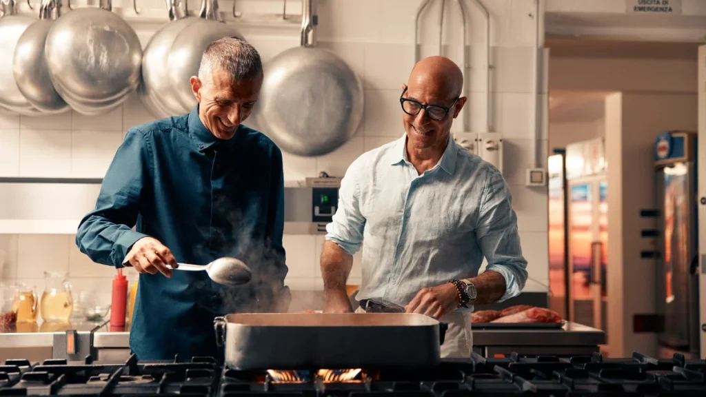 Stanley Tucci s lokálnym šéfkuchárom pri príprave tradičného jedla v talianskej reštaurácii.